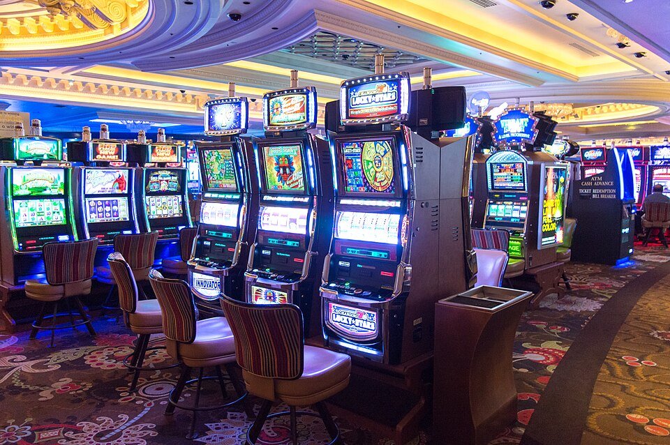 Row of illuminated slot machines in a gaming hall